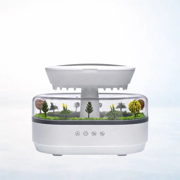 Aroma raindrop humidifier with miniature tree landscape in transparent compartment, white background