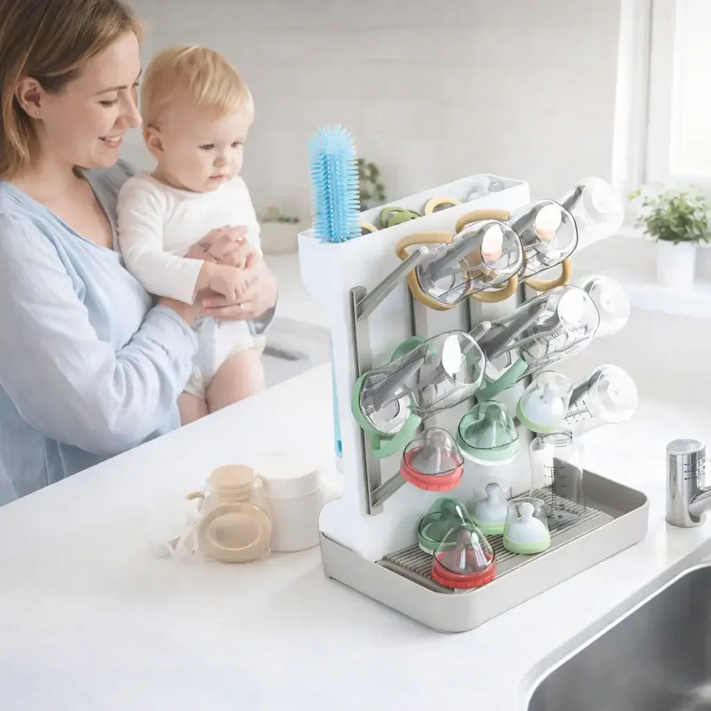 Baby bottle drying rack on kitchen counter with bottles and nipples, woman holding baby nearby