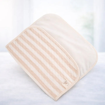 Washable beige striped cot pad on soft white surface, nursery bedding accessory