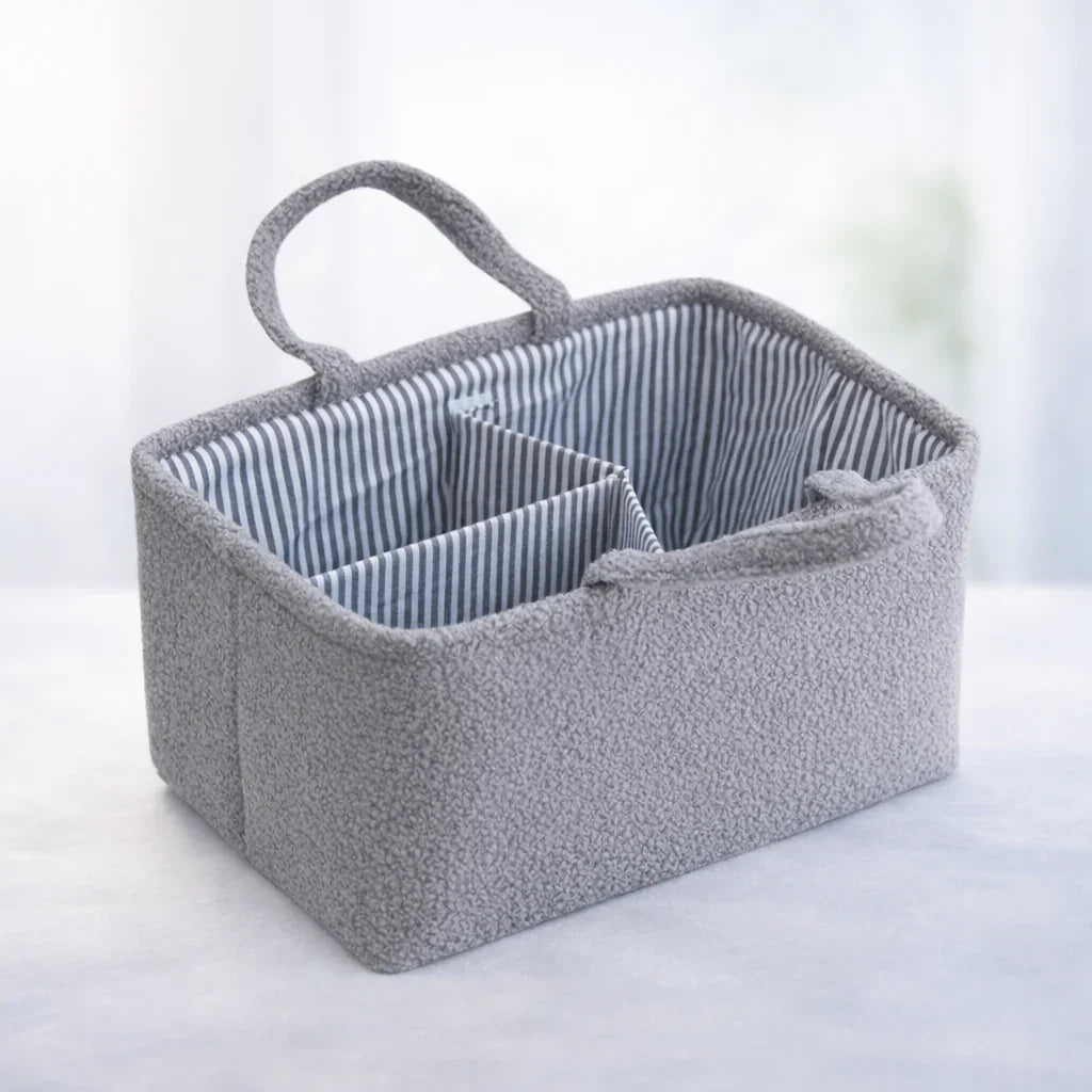 Gray nursery storage caddy with handle, striped interior, and multiple compartments