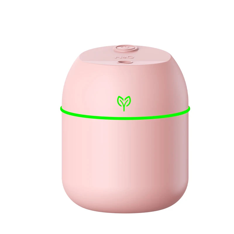 mini usb humidifier diffuser in pink with soft green light, minimal column-style design displayed on a white background.