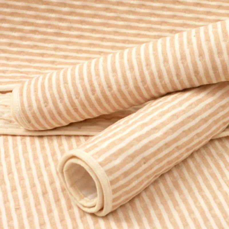 Beige and white striped fabric rolls with soft texture, textile material close-up