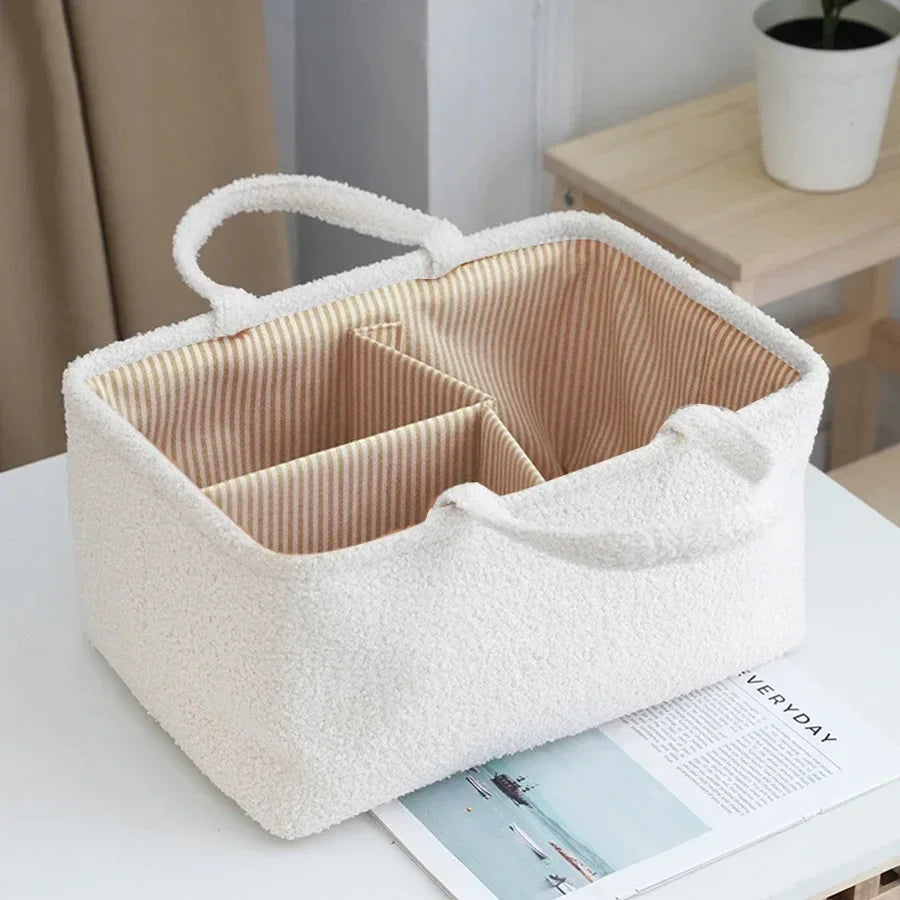 Soft fabric storage basket with handles and striped compartments on a white table