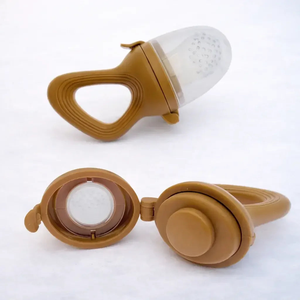 Coffee-colored silicone baby fruit feeder with handle and cap, displayed on white background.