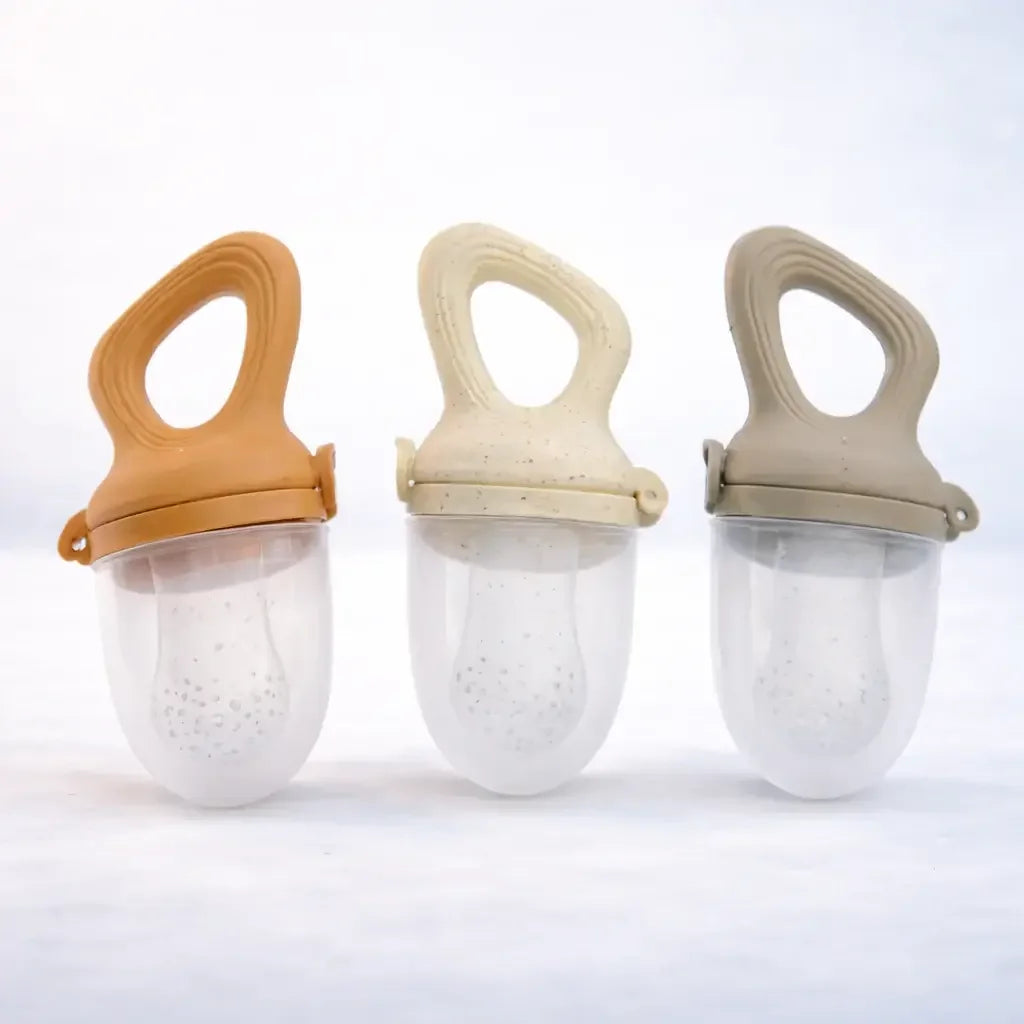 Set of three silicone baby fruit feeders in beige, tan, and taupe with ergonomic handles
