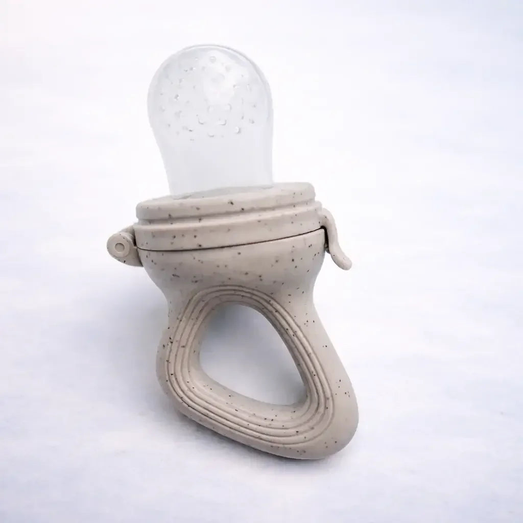 Silicone baby fruit feeder with speckled handle on white background
