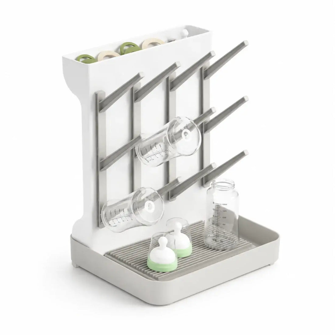 White dish drying rack with glassware and bottles on a white background