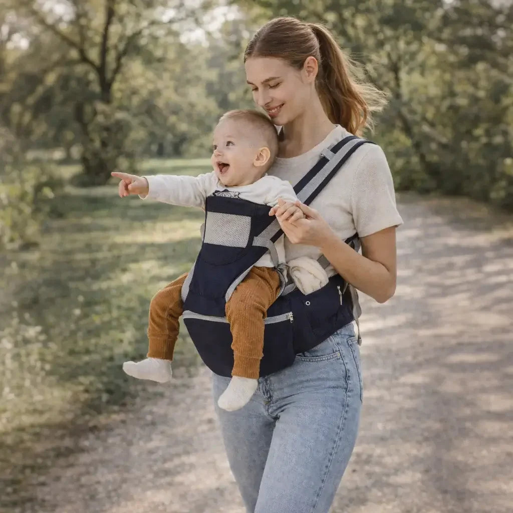adjustable baby carrier - Mother carrying baby in adjustable ergonomic baby carrier outdoors on a nature trail