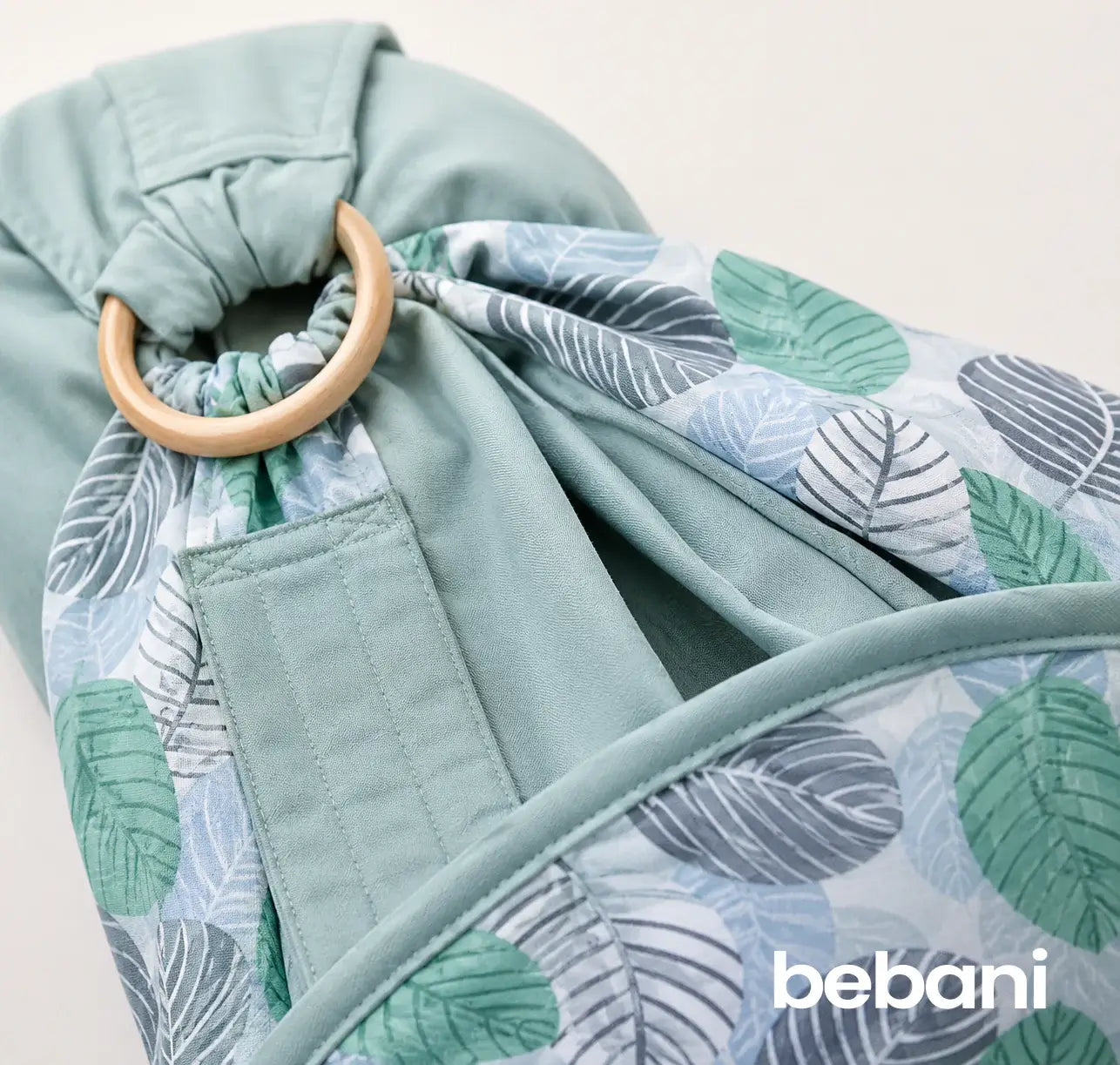 Close-up of the Embrace Wrap™ featuring a leaf design and wooden ring, ideal for baby wrap newborn sling.