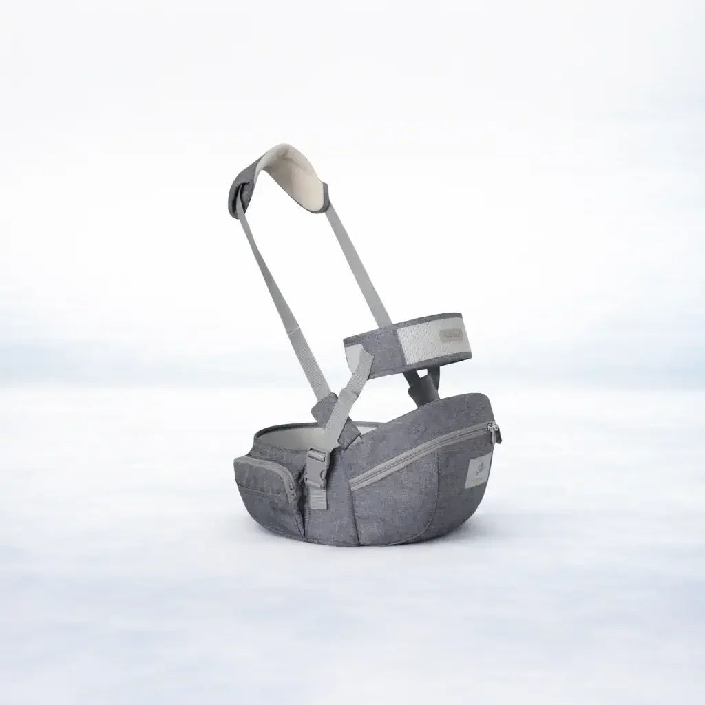 Gray ergonomic baby hip seat carrier with adjustable straps and zippered pockets on white background