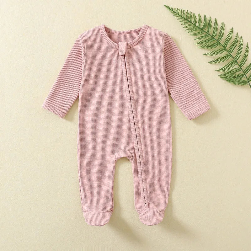 Organic Ribbed Zip Baby Romper in pink with zipper on beige background for soft everyday wear